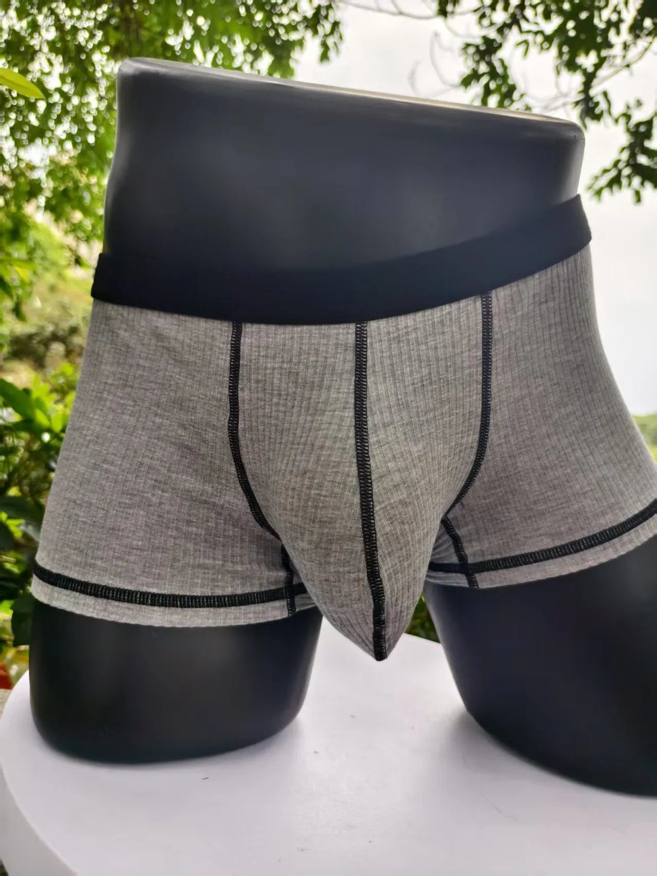 Solid colour men's boxers in breathable thin fabric offering hip lifting and body shaping support.