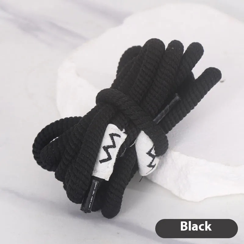 Oval cross-section shoelace adapter rope in various colours, shown next to a trainer and sweatshirt.