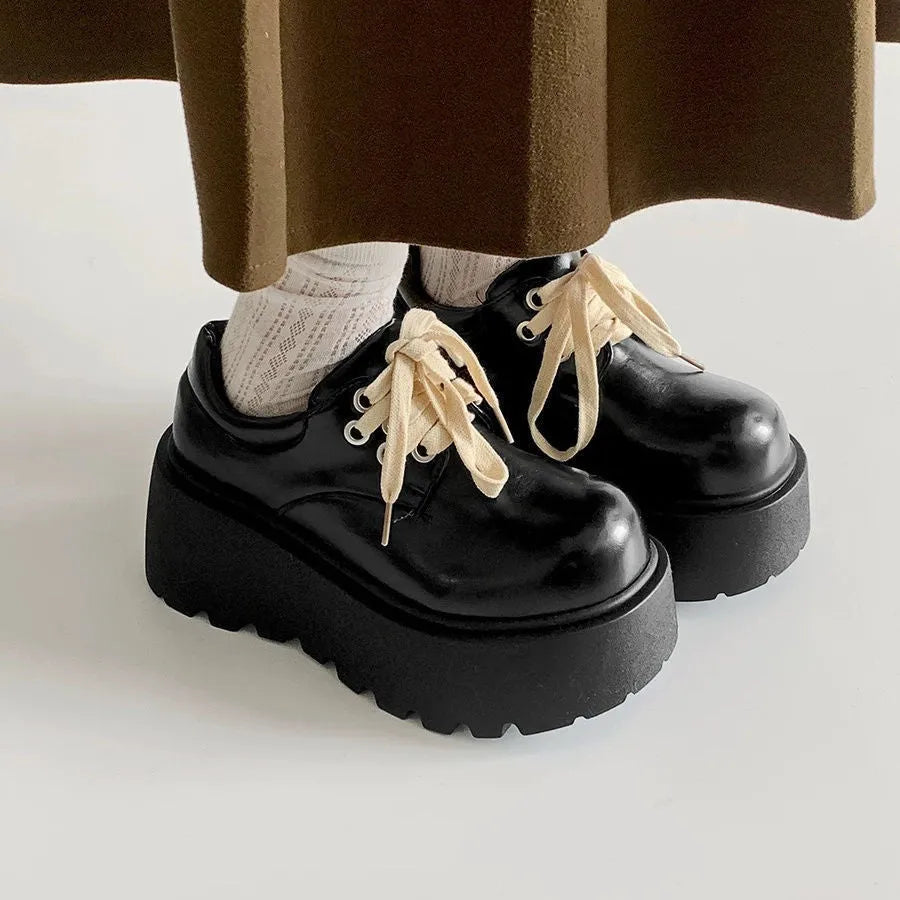 Women's matte black lace-up shoes with a high muffin heel and thick rubber sole.
