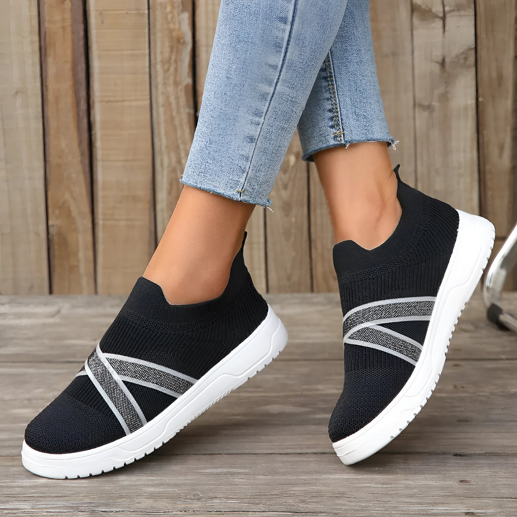 Black women's low-top flyknit mesh shoes with flat rubber sole and tassel detail.