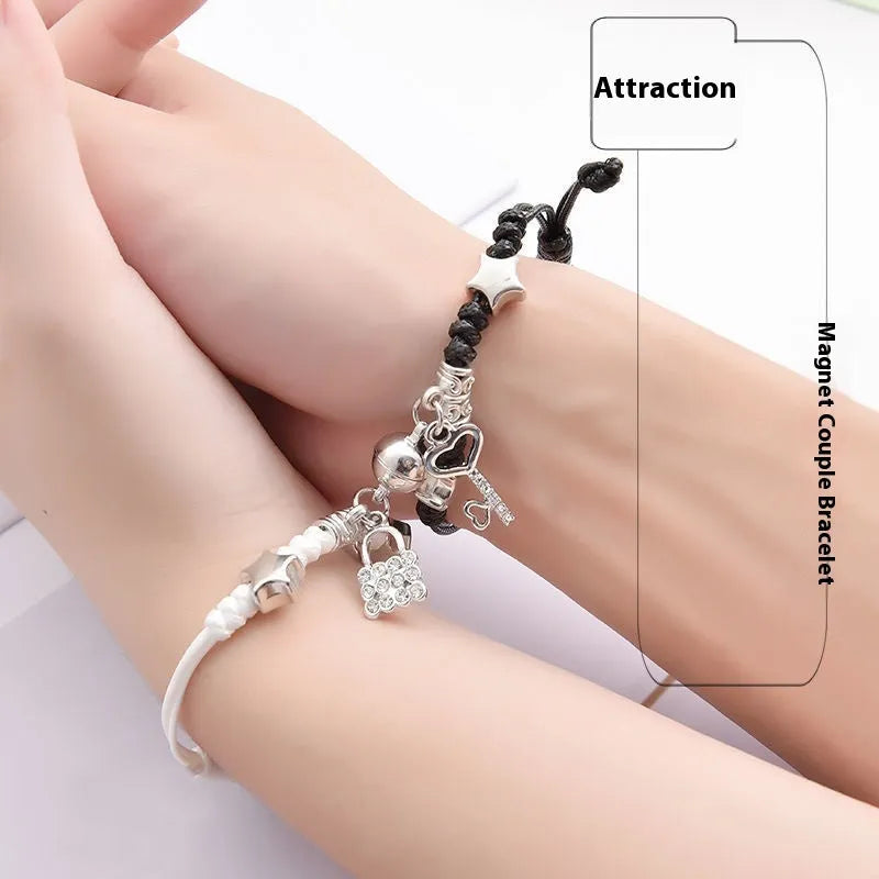 Pair of magnetic suction bracelets with alloy charms in various love and friendship themed designs on a wrist.