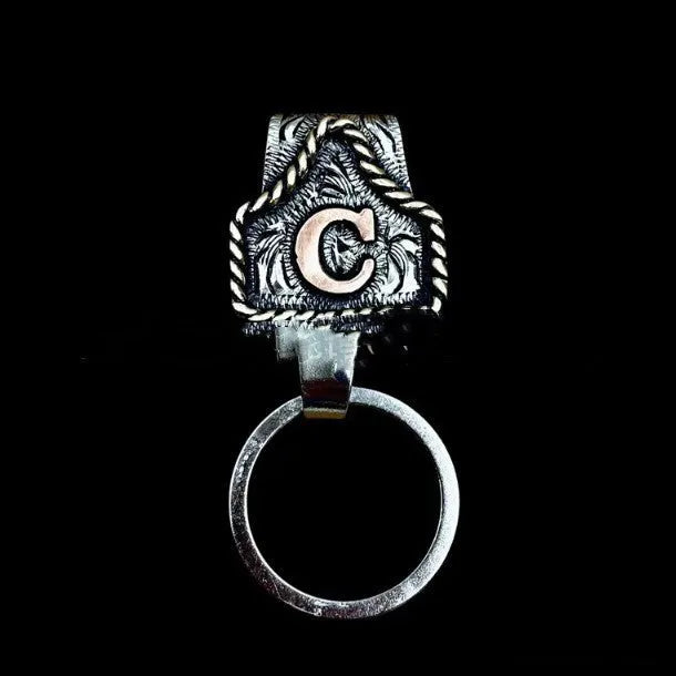 Handmade metal keychain with a cow tag charm in one of 26 available colour options.