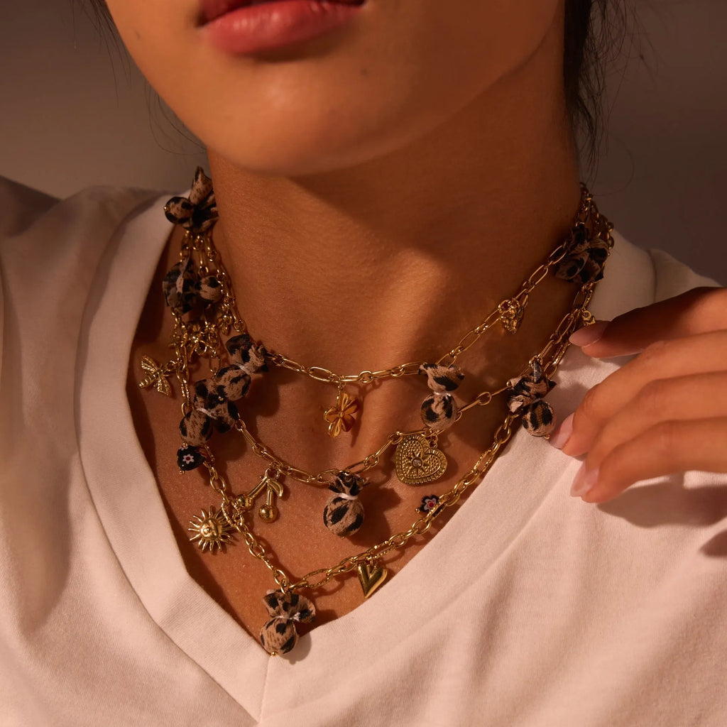 Geometric leopard and heart pendant stainless steel necklace on a model, showing adjustable chain.