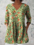 A woman wearing a loose-fitting printed dress with 3/4 sleeves and a wide waist.