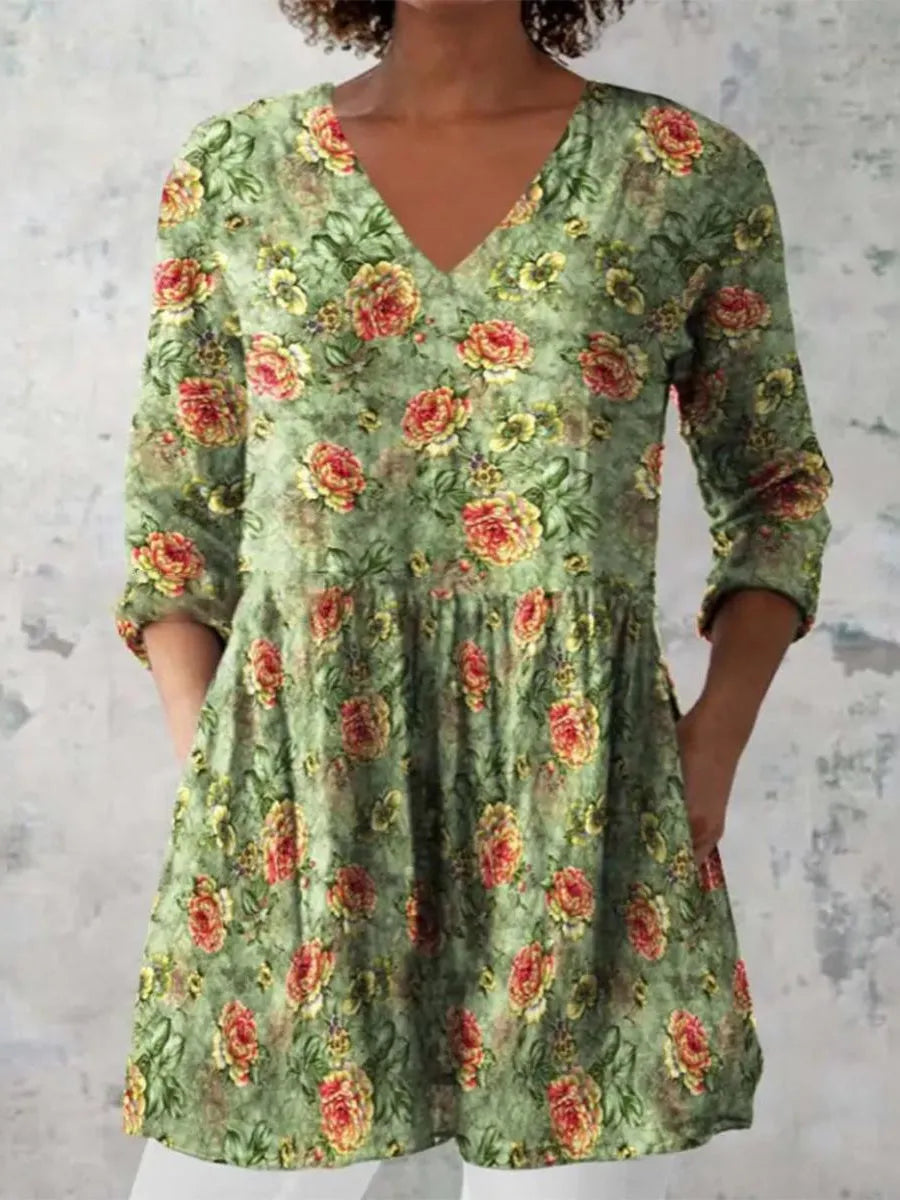 A woman wearing a loose-fitting printed dress with 3/4 sleeves and a wide waist.
