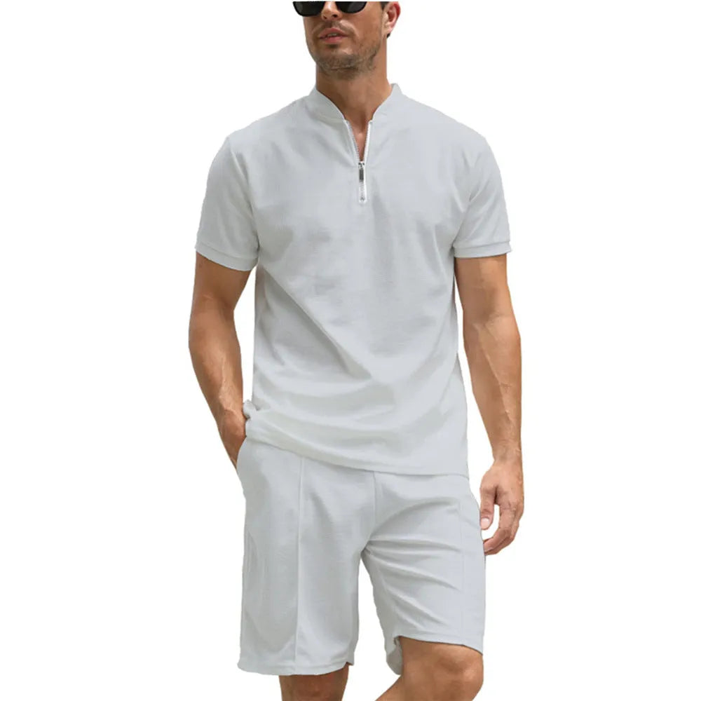 Man wearing a solid colour polo shirt and matching trousers from a two-piece set in beaded bird's eye polyester fabric.