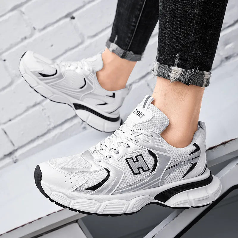 Men's white and grey mesh running shoes with a round toe and plastic sole on a plain background.