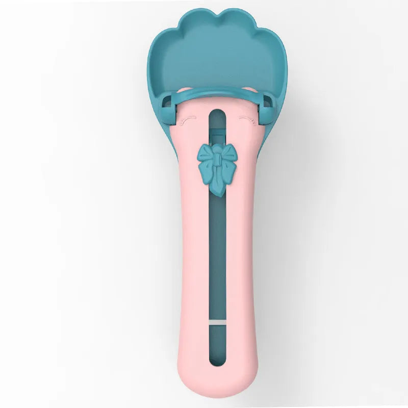 Pink and green pet feed spoon with squeezer mechanism for wet food and treat dispensing
