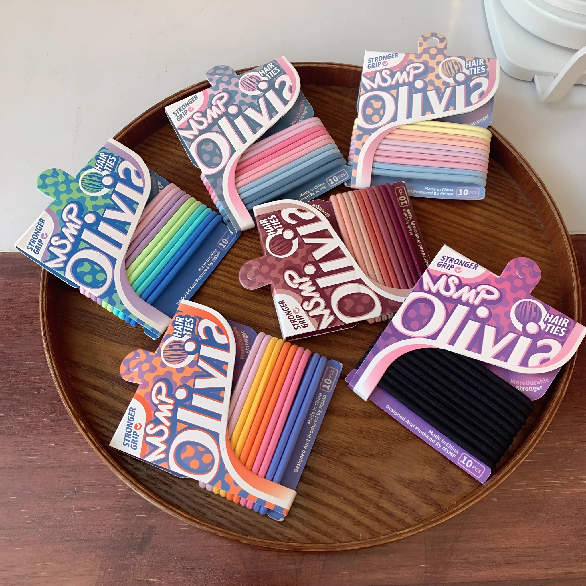 Assortment of candy colour braided elastic hair bands laid flat, showing textured rubber design.
