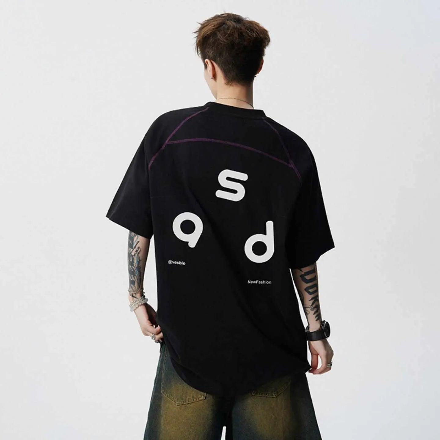 A loose-fitting black cotton t-shirt with letter print detail on the front, showing short sleeves and a round neck.