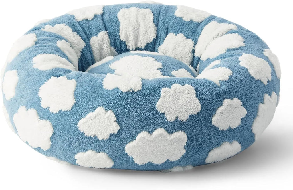 Round plastic dog bed with a blue and white plaid fabric cover, shown on a wooden floor.
