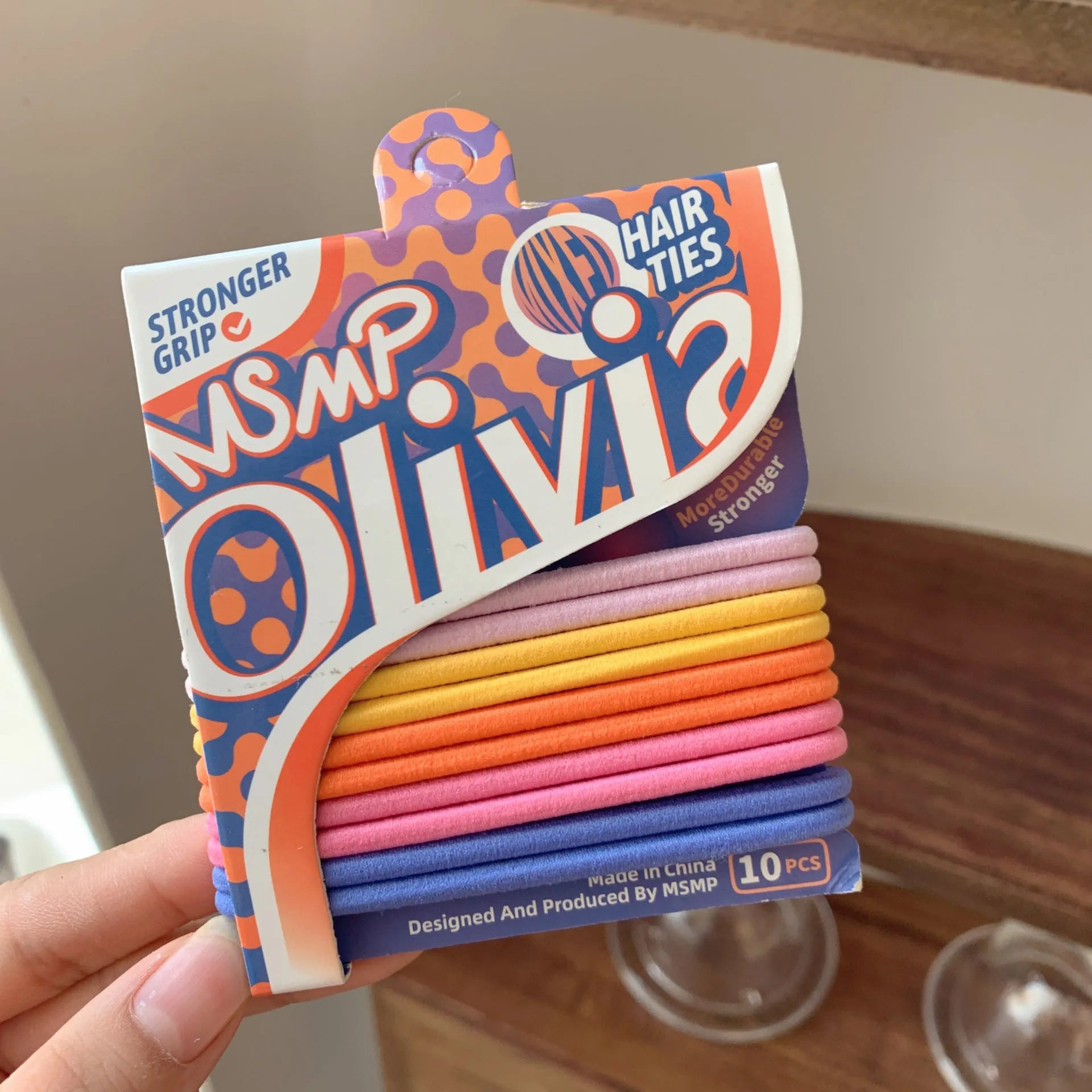 Assortment of candy colour braided elastic hair bands laid flat, showing textured rubber design.