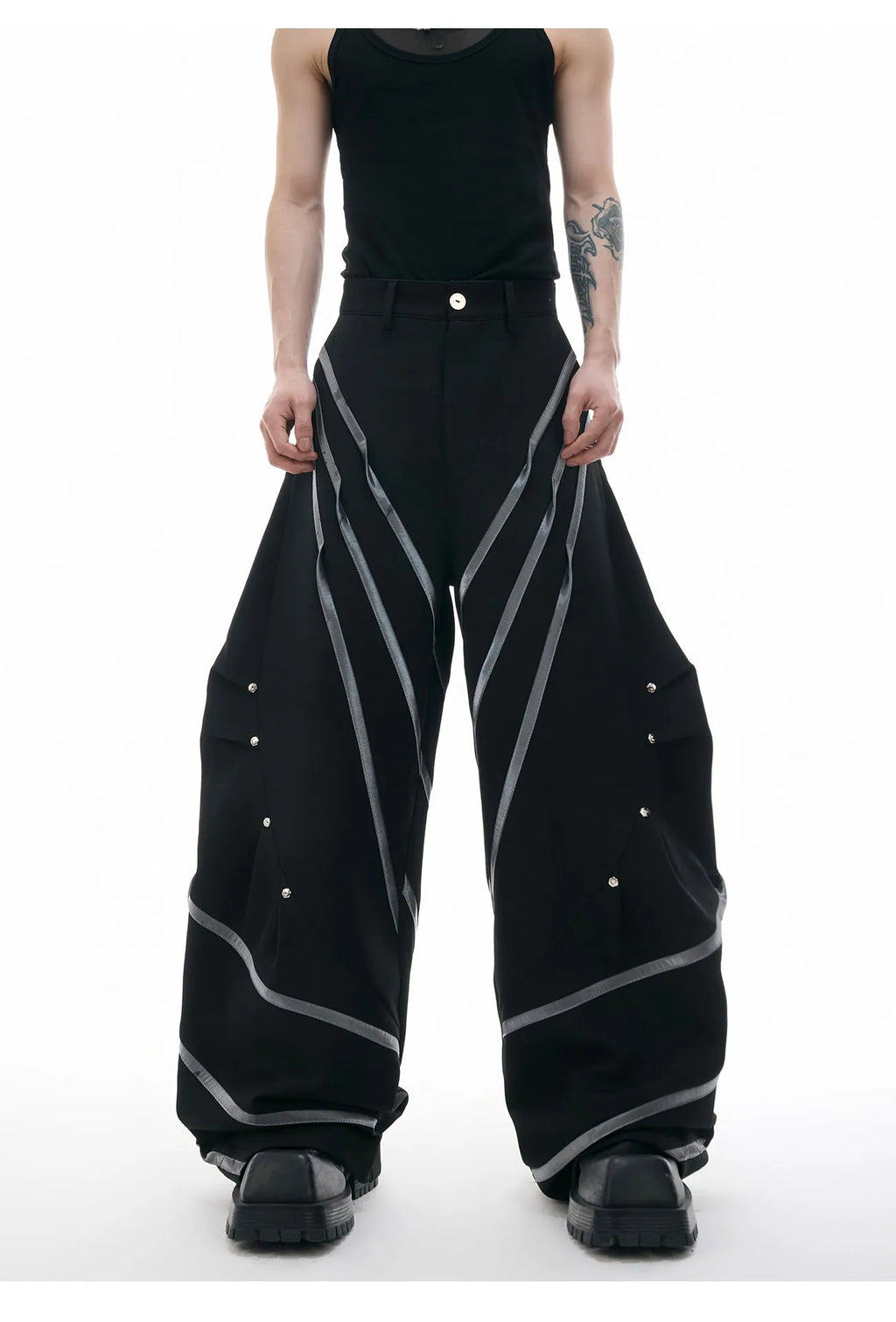 Men's black trousers with three-dimensional cut and silver metal rivet pleat detailing.