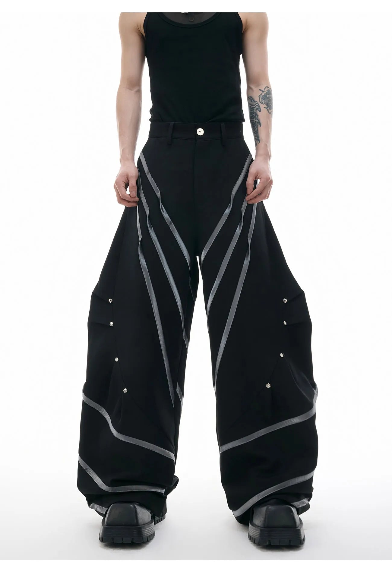 Men's black trousers with three-dimensional cut and silver metal rivet pleat detailing.