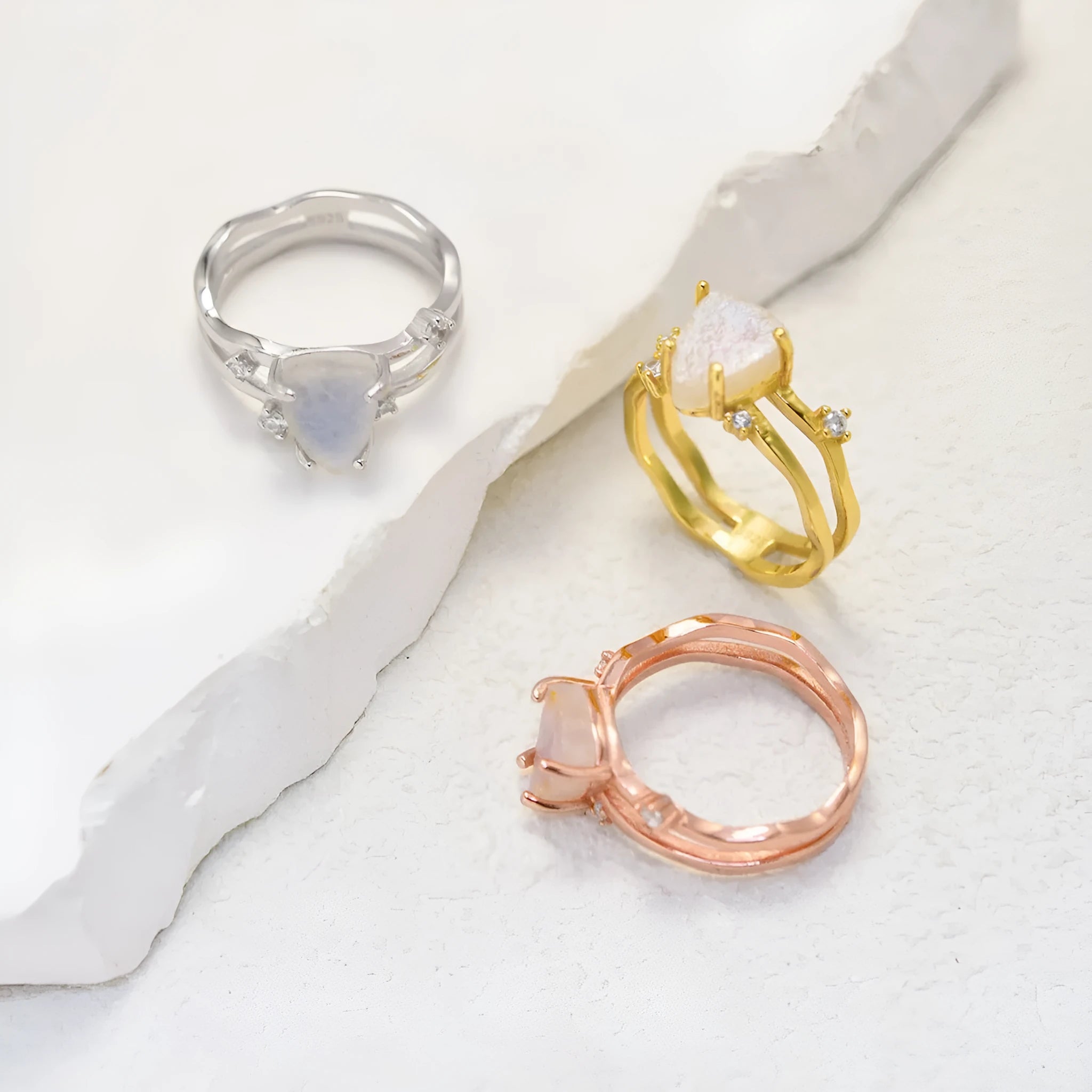 S925 silver geometric ring with irregular triangle shape and central moonstone on a model's hand.