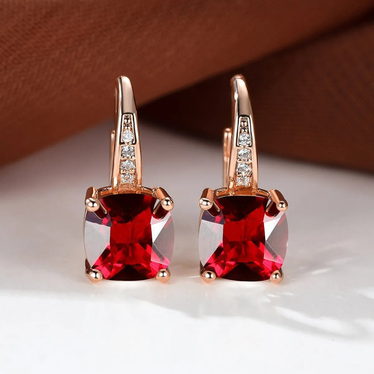 Square geometric ear hook studs with a round zircon stone, shown in a gold electroplated finish.