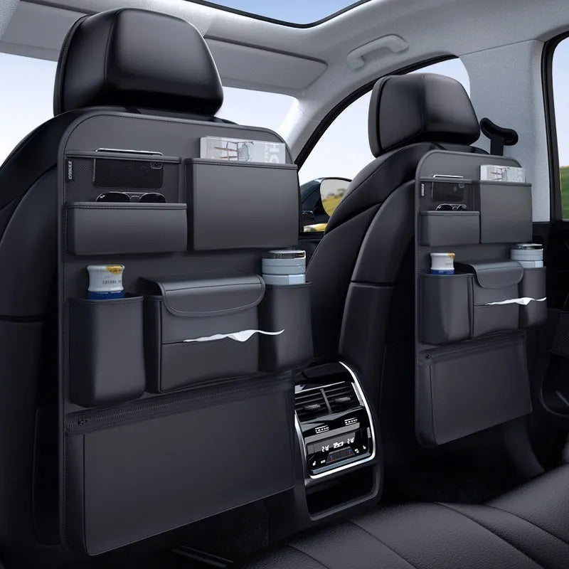 Black leather car seat back hanging storage organiser bag with handle shown mounted on a headrest.