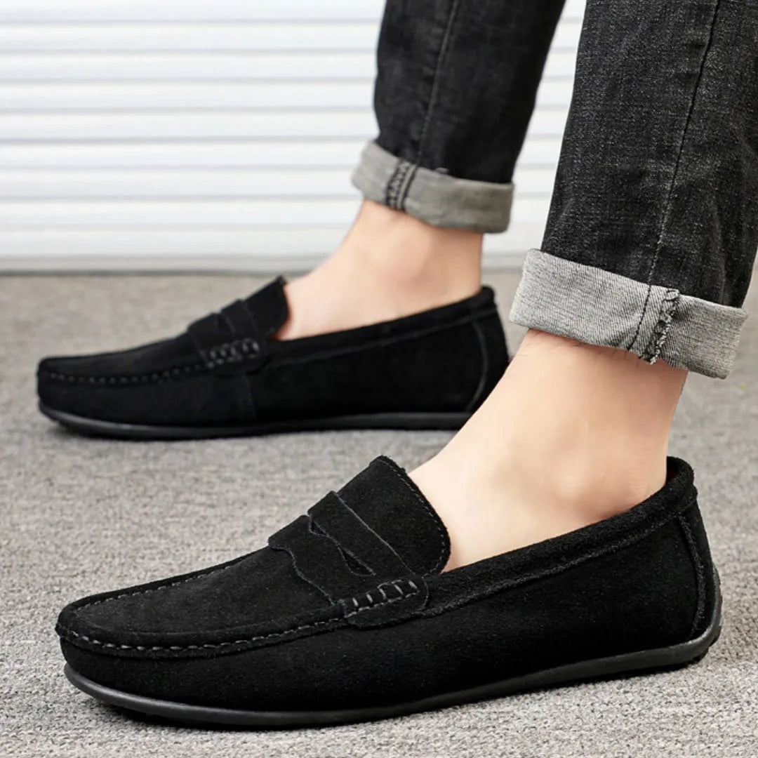 Men's solid colour suede loafers with round toe and rubber sole on a neutral background.