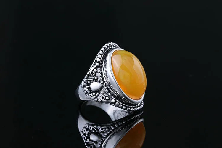Geometric retro alloy ring in antique silver amber colour on a plain background.