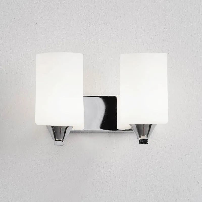 Minimalist chrome-finished glass wall lamp with single head configuration on white wall