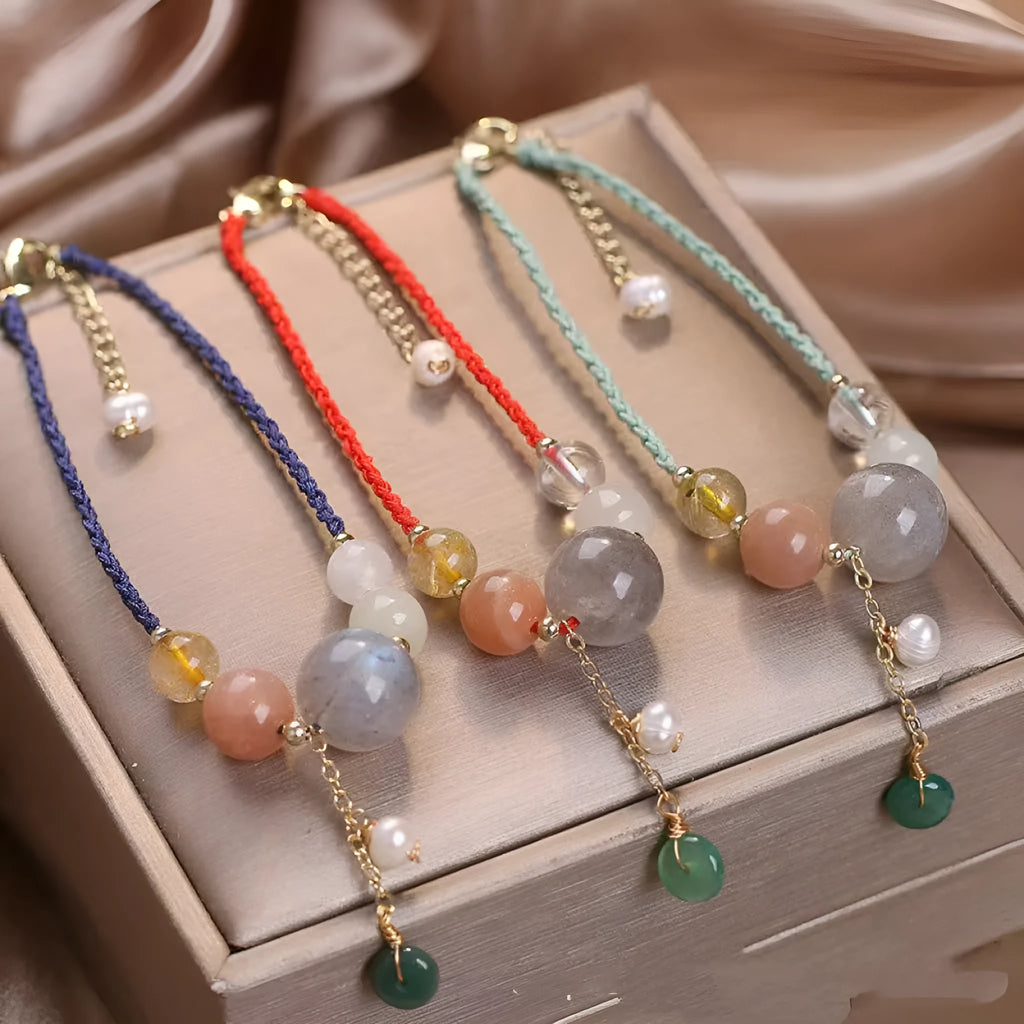 Women's hand-woven bracelet with peace buckle closure and crystal sequins in red, green, and blue colour options