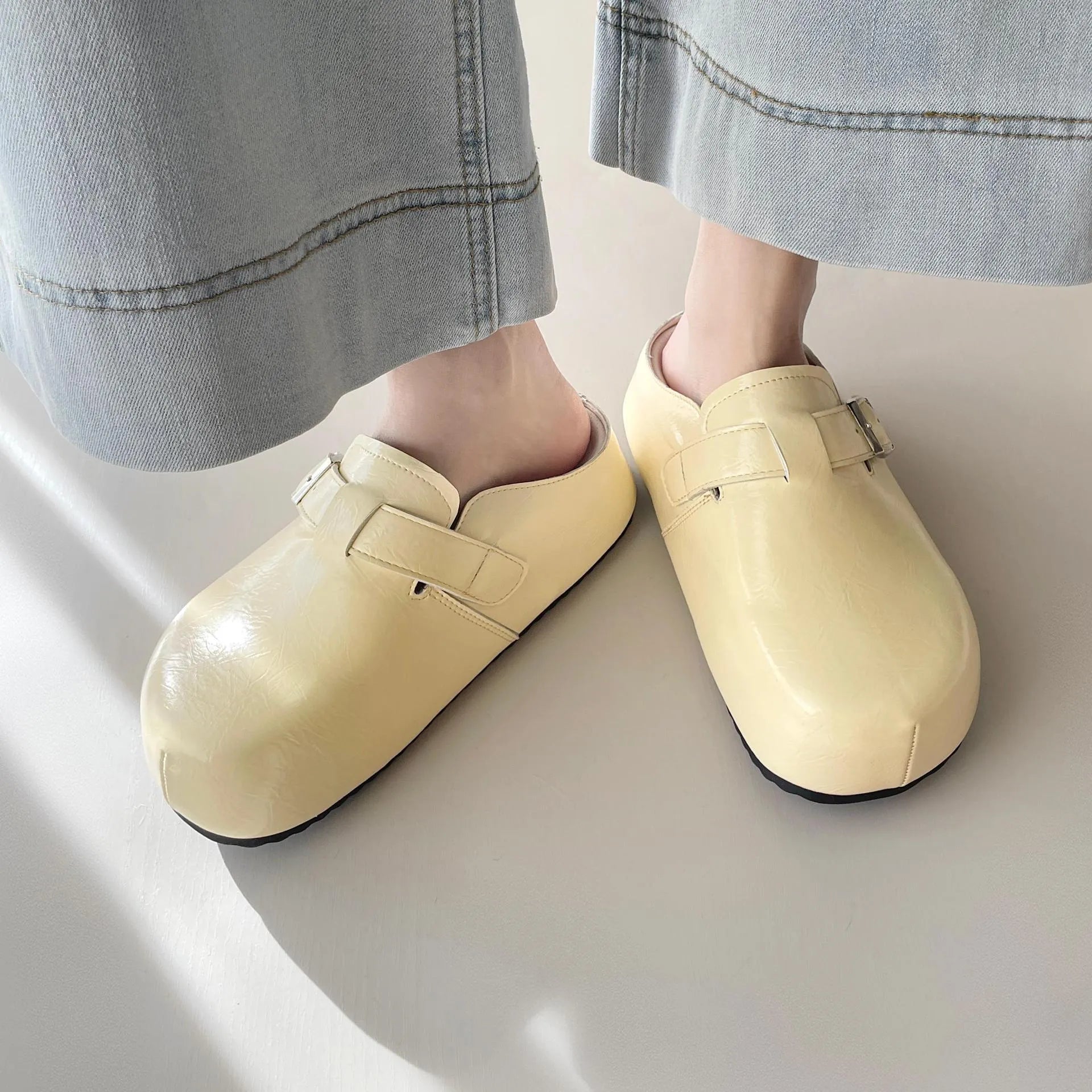 Women's flat buckle casual sneakers in yellow, creamy-white, silver, and black colours with round toe design