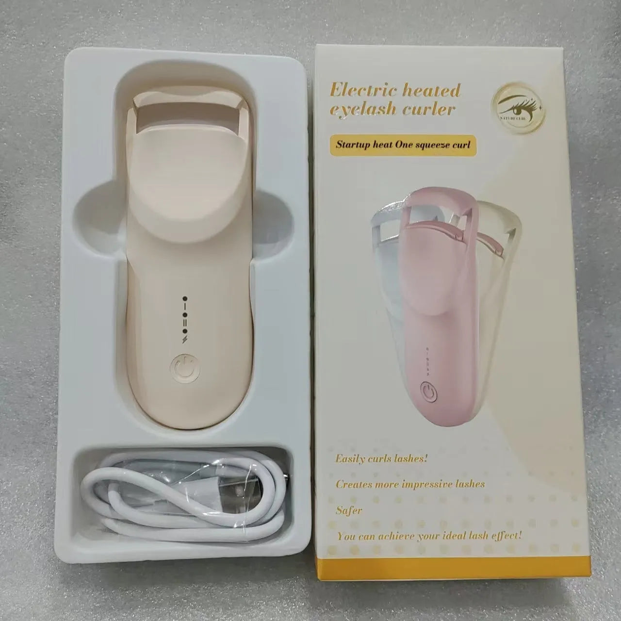 Electric heating eyelash curler in plastic housing with USB cable on a vanity