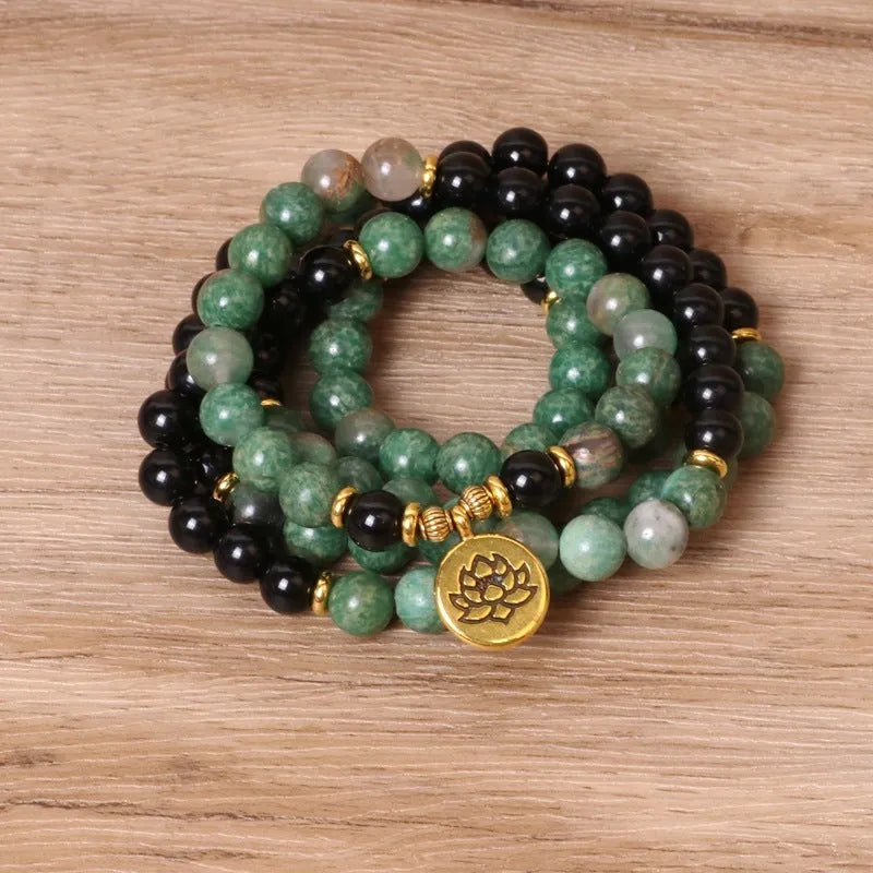 Green and black elastic beaded long bracelet with alloy components stretched on wrist