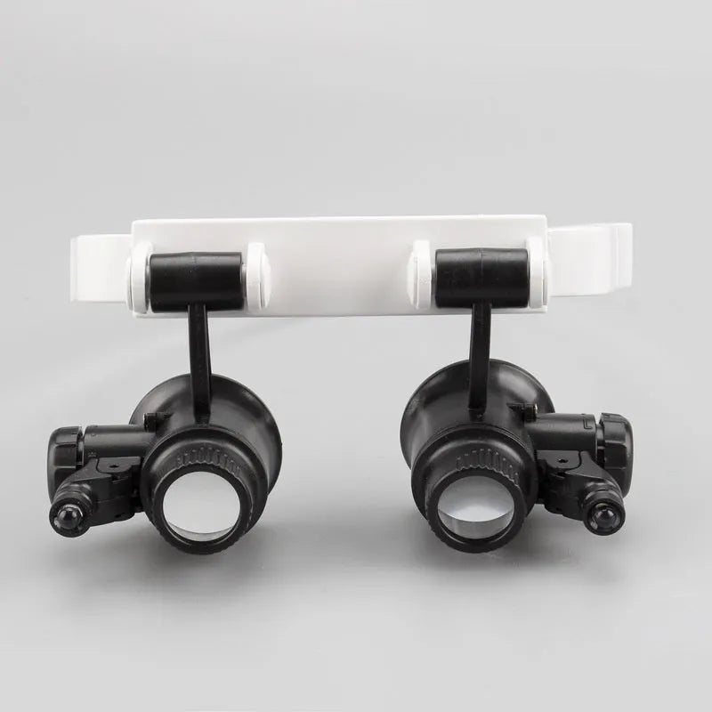 White head-mounted magnifying glass with 30x lens and built-in light, shown folded and unfolded.