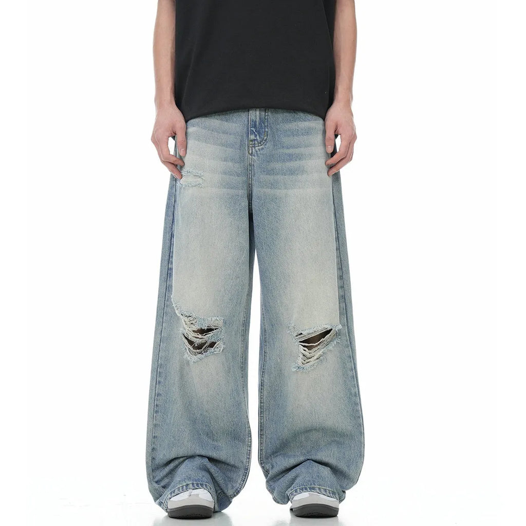 Denim blue straight-leg jeans with ripped details and zip fly closure
