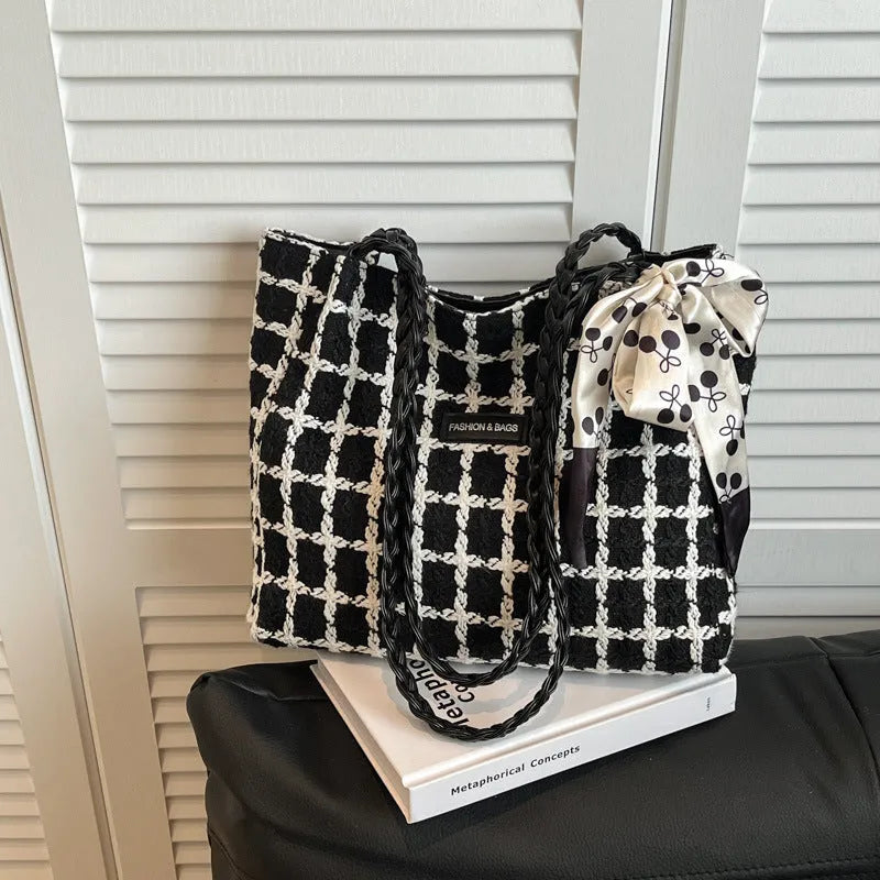 Black woven wool shoulder bag with horizontal square design showing internal organisation pockets and exterior sandwich compartment