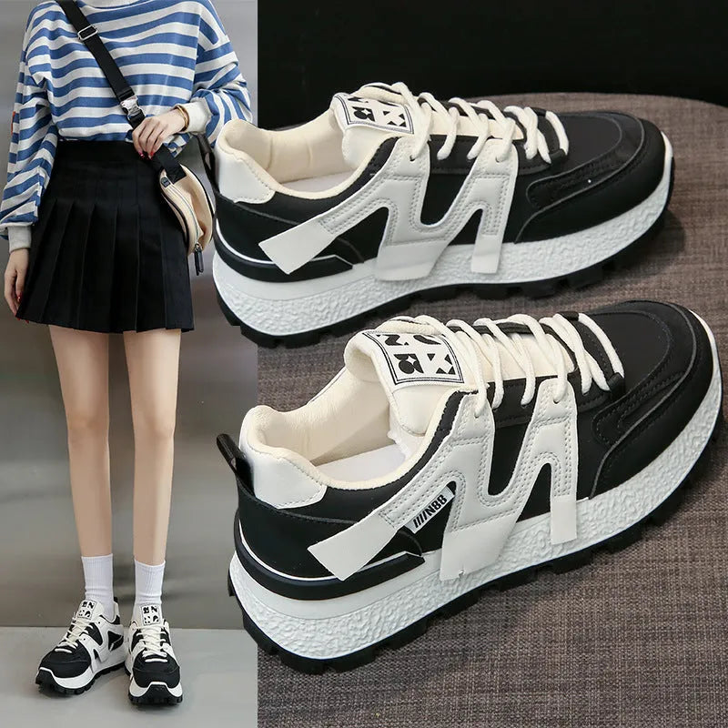 A pair of solid-colour low-top lace-up sneakers with a round toe and flat rubber sole.