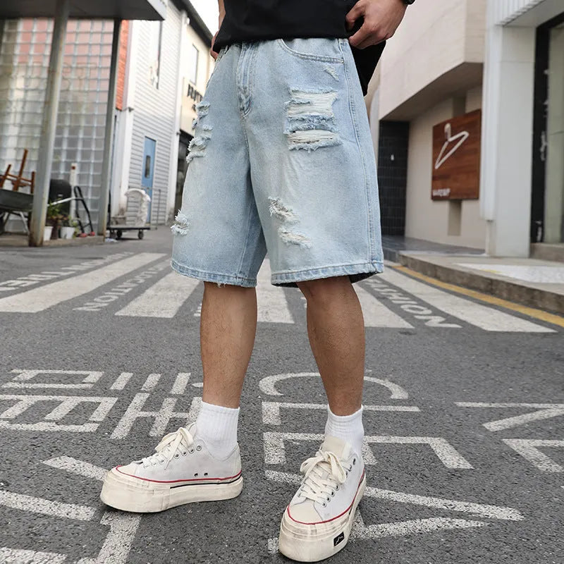 Light blue ripped denim shorts with a loose, straight-leg fit on a neutral background.