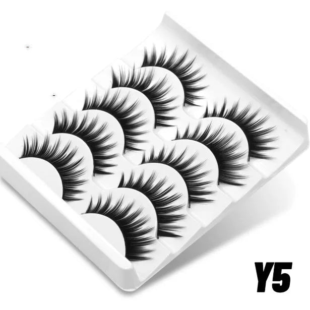 Box of natural long, thick false eyelashes made from artificial fibre with included glue tube.