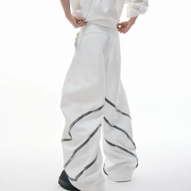 Men's black trousers with three-dimensional cut and silver metal rivet pleat detailing.
