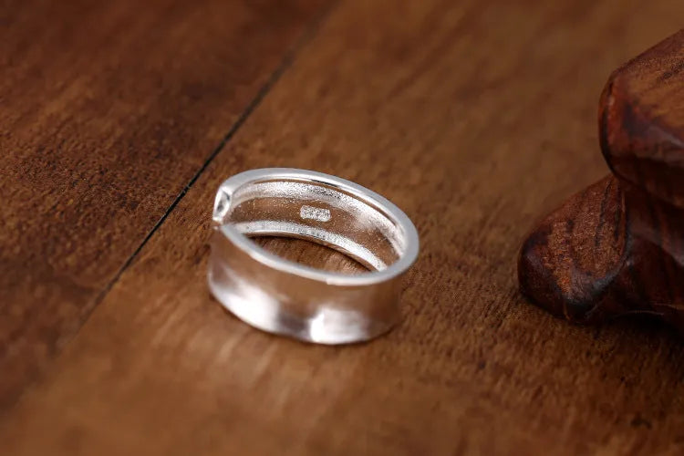 Frosted silver geometric open ring with adjustable sizing on a neutral background