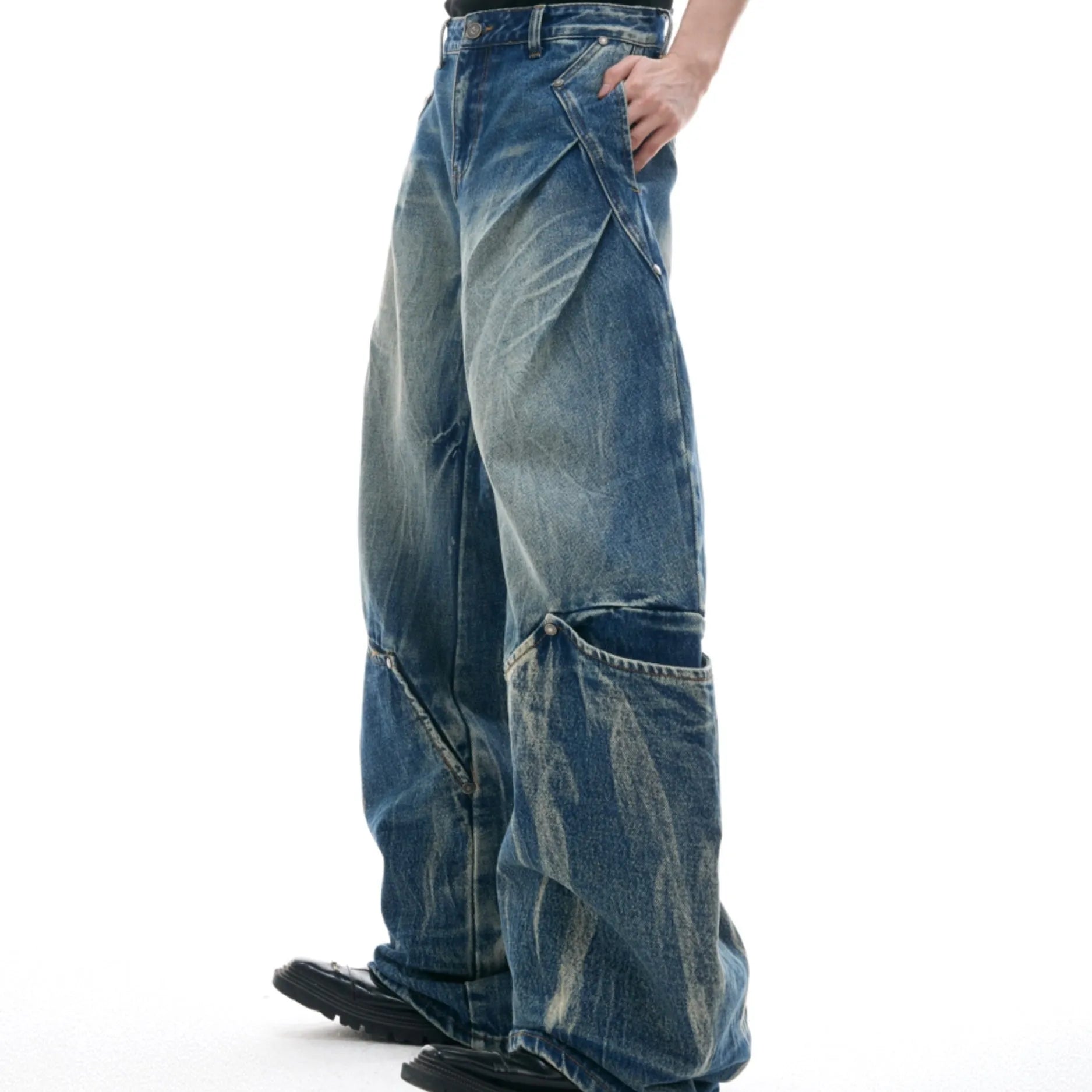 Man wearing verdant blue retro washed burst pattern loose fit jeans with a curved knife design.