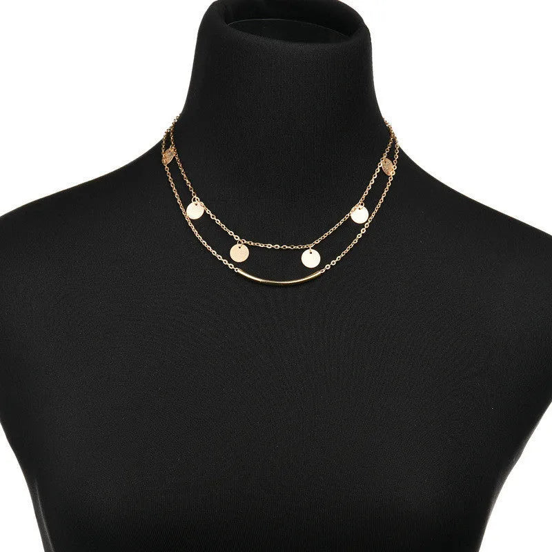 Gold alloy geometric pendant necklace with multi-sequin finish on display