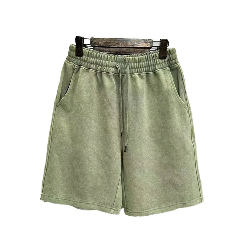 Men's solid colour cotton shorts with distressed detailing on the leg, shown in a loose, straight-leg fit.
