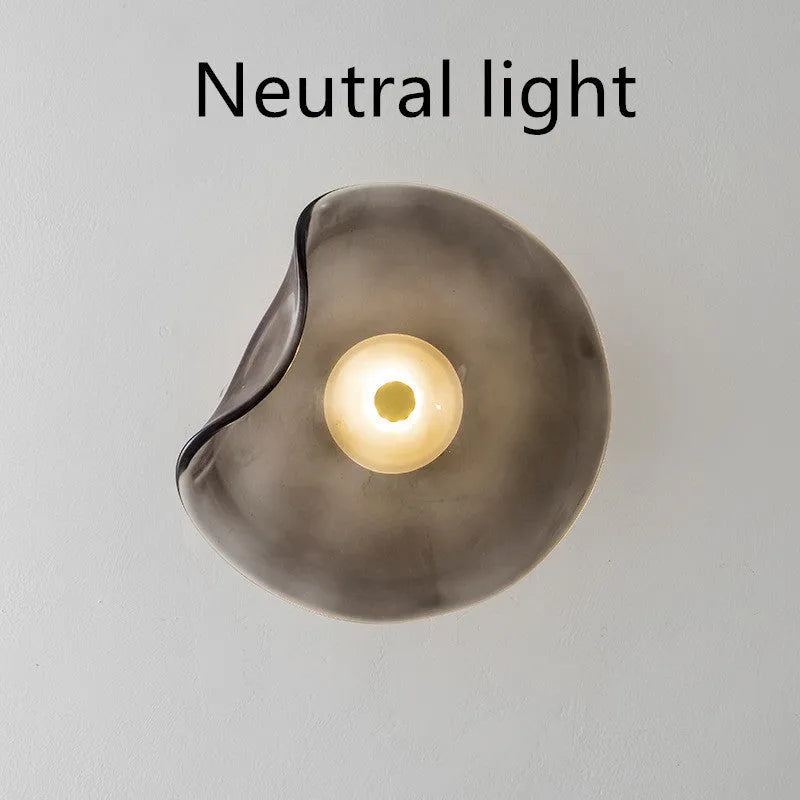 Round glass bedside wall lamp in cognac, light purple, or smoky grey colour.