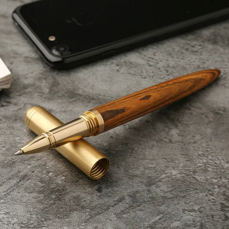 Brass and sandalwood solid wood signature pen with wooden barrel and brass fittings on a desk