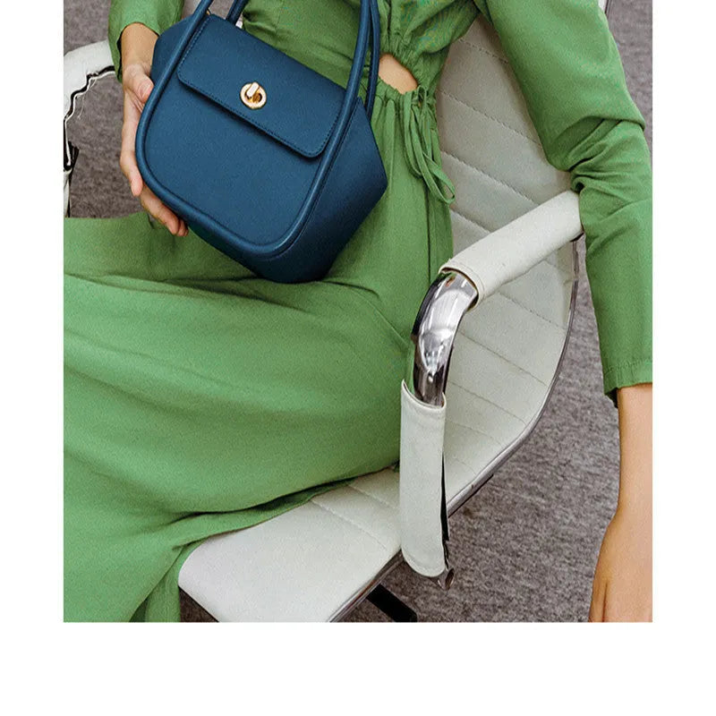Women's leather wing-shaped tote bag with buckle closure in blue, grey, black, or brown colour options