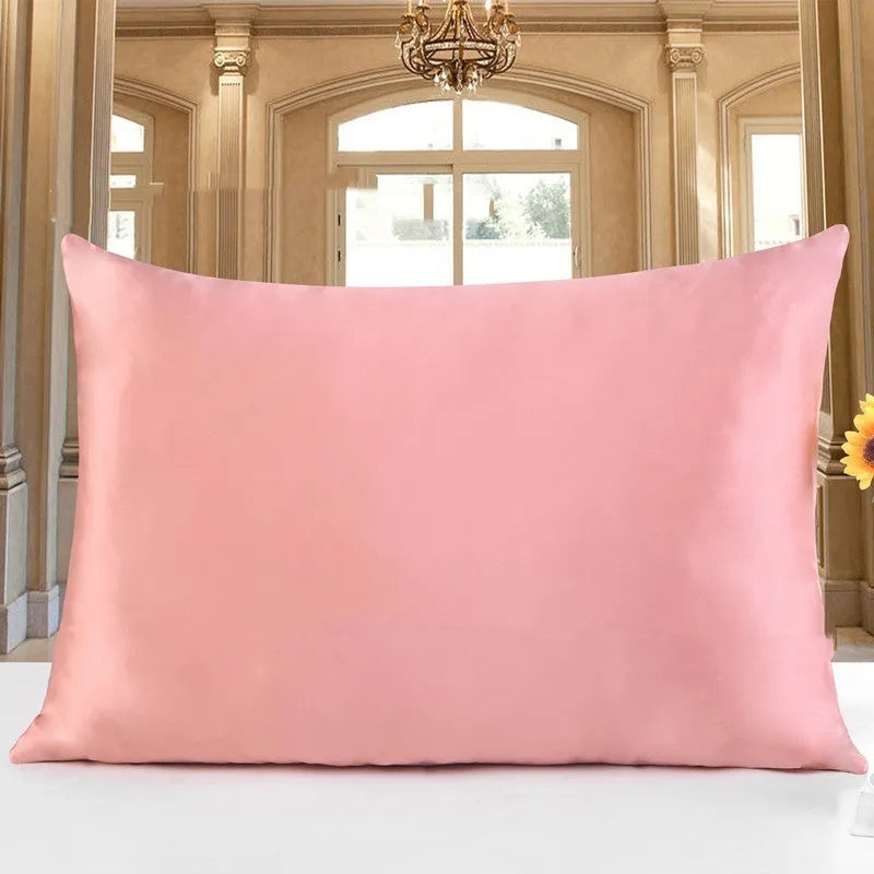 19 M double-sided silk pillowcase in apricot colour on a bed.