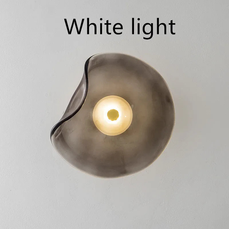 Round glass bedside wall lamp in cognac, light purple, or smoky grey colour.