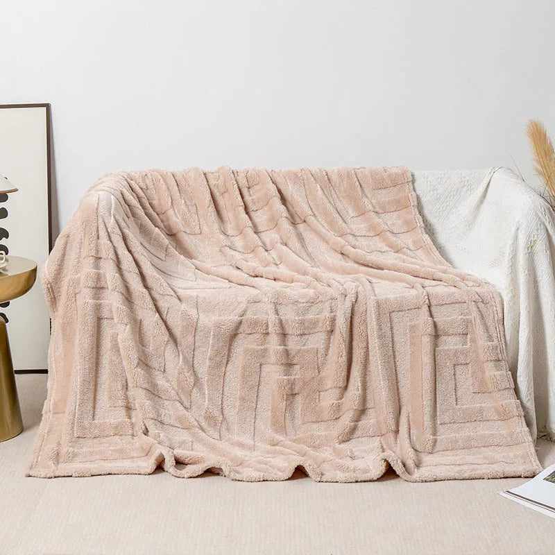 Thick square coral fleece blanket in a solid colour, draped over a sofa.