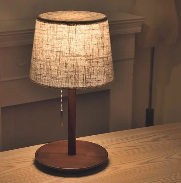 Walnut-coloured solid wood bedside lamp with fabric shade and cable switch