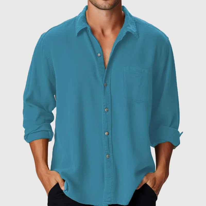 Man wearing a loose fit long sleeve beach shirt with a stand collar in a solid colour.