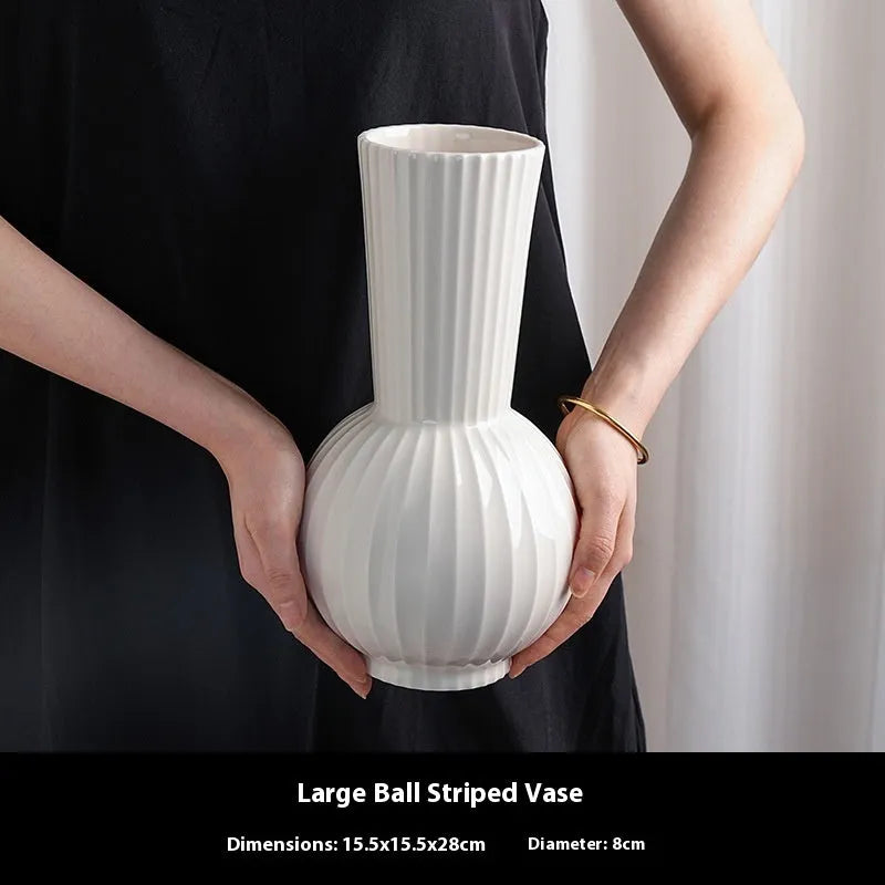 White ceramic ball vase with striped patterning in American country style on wooden table