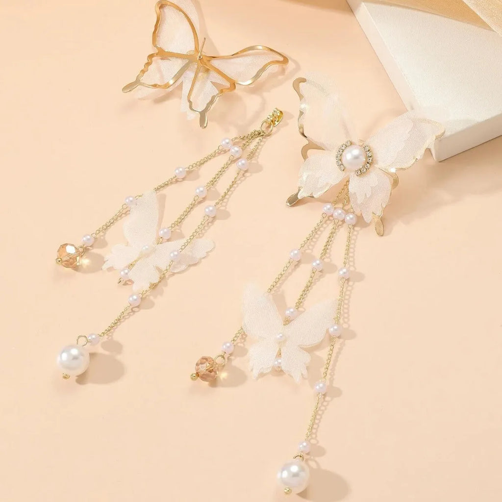 White butterfly-shaped drop earrings with pearl and rhinestone accents on a tassel lace design.