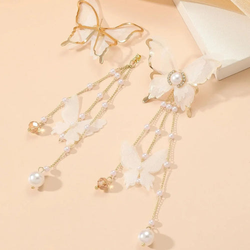 White butterfly-shaped drop earrings with pearl and rhinestone accents on a tassel lace design.